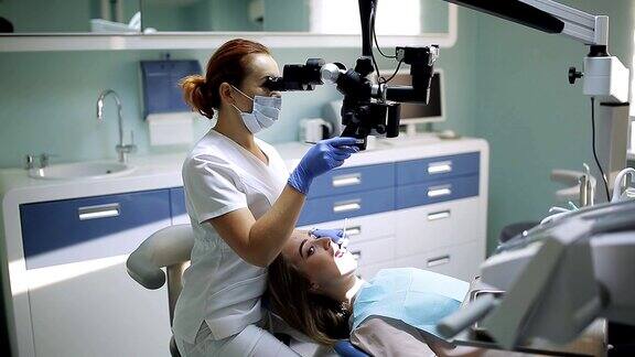 女牙医使用牙科工具-显微镜镜子和探针在牙科诊所治疗病人的牙齿医学、牙科和保健概念牙科设备