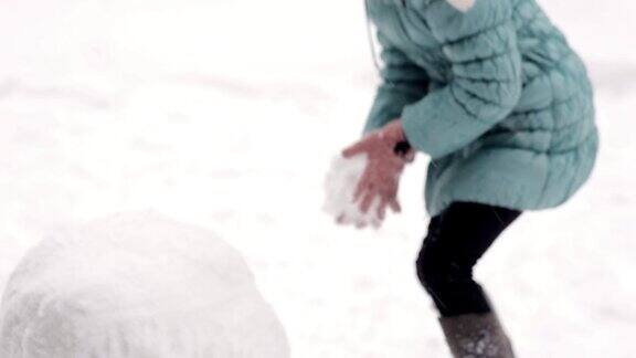 女孩冬天在雪地里堆雪人