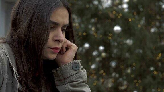 沮丧悲伤孤独的年轻女人在圣诞节的时候在室外哭泣