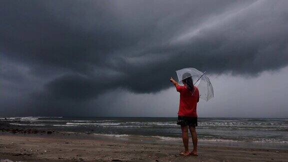 4k:女人看着海面上的大风黑色风暴架云
