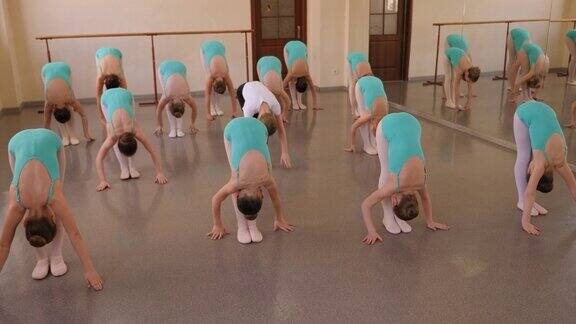 一群孩子在芭蕾舞室上舞蹈课前做热身运动