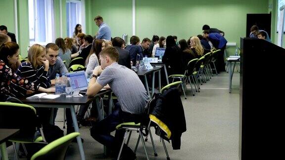 大学的现代教育过程听众中有很多学生坐在桌子旁用笔记本电脑学习信息大型宽敞的类