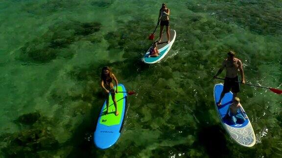 一家人在夏威夷的热带海滩上玩桨