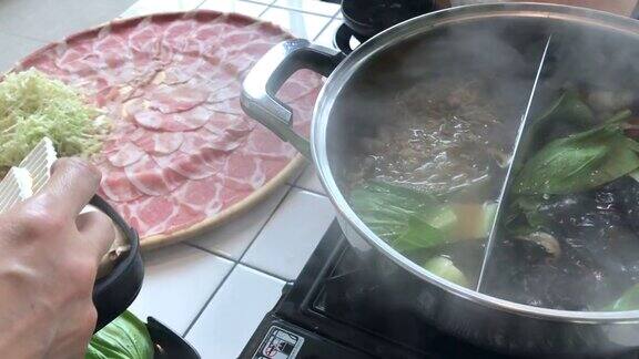 泰国曼谷将猪肉切片放入火锅中