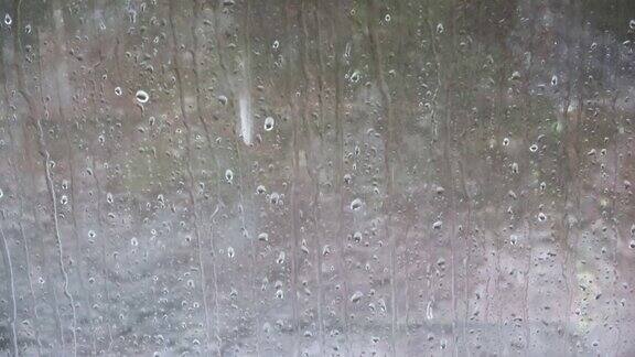 在近距离的观察中雨滴沿着窗户往下跑