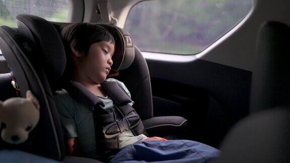 亚洲小男孩睡在汽车座椅上