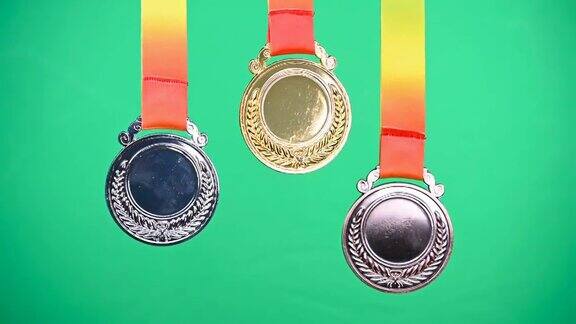 一套金牌银牌和铜奖奖牌在一个绿色的背景