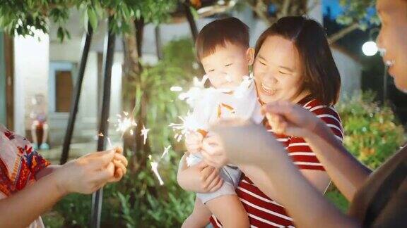 在户外庆祝时欢乐的家庭手拿焰火