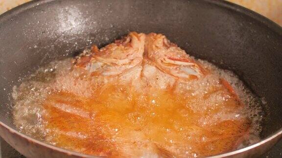特写的鱼油炸在一个黑色的平底锅