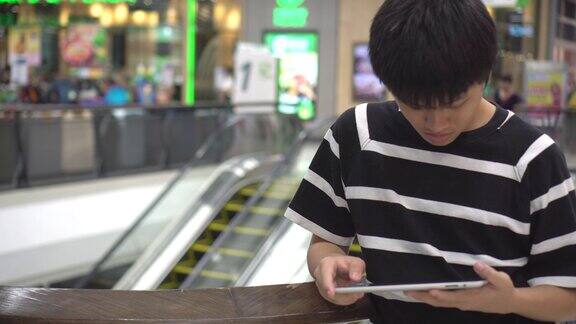 青少年在商场里玩平板电脑