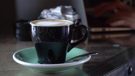 木桌上的热咖啡最好的卡布奇诺新鲜的烟熏咖啡茶几上的瓷咖啡杯配冷水有选择性的聚焦和自由的文字空间工业食品饮料概念