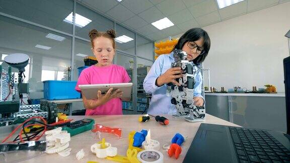 两个孩子在学校实验室里建造一个塑料机器人技术教育