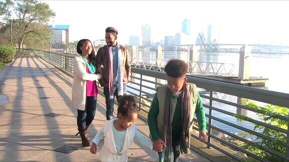 一家人两个孩子在城市海滨散步聊天