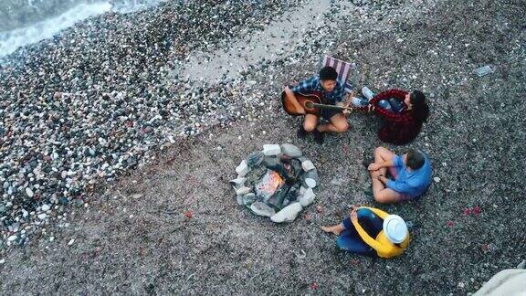 年轻的朋友们在篝火旁欣赏音乐