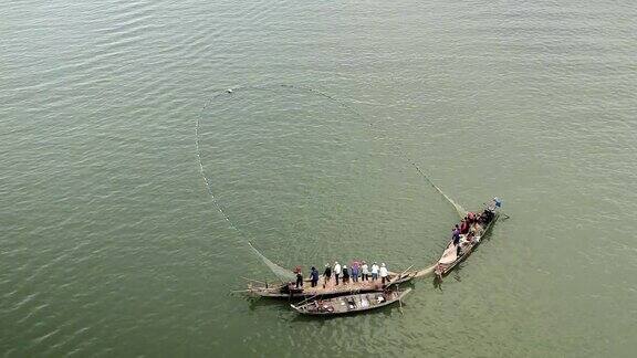 渔民们在小船上把一张大网拉出水面