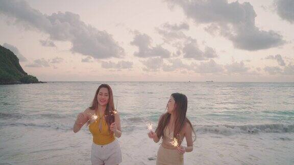 两个女人在海滩上玩烟花跳舞
