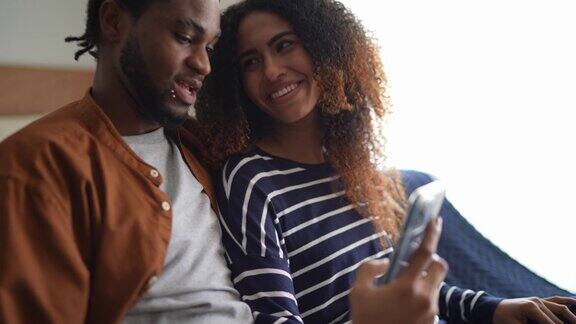 幸福的年轻夫妇在家里用智能手机在线订餐