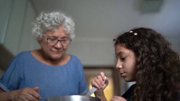 奶奶在家里和孙女一起做巧克力