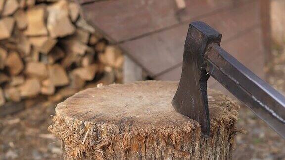 这把砍柴机在木麻中伸出来木工斧头砍木头生锈但很锋利的伐木工斧子特写的斧头切割原木而其他原木躺在背景