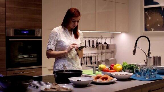 在厨房里用智能手机的女人