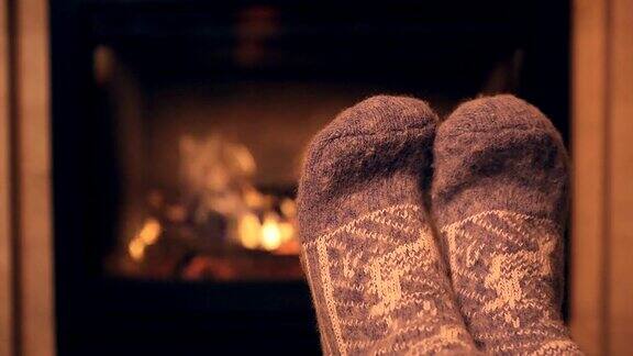 穿着羊毛袜子的脚在壁炉旁