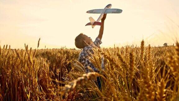 小男孩在田野里玩飞机玩具
