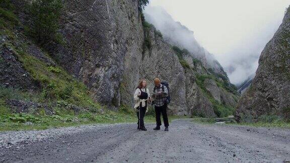 俄罗斯高加索地区一对年轻的游客正沿着岩石间的路走着
