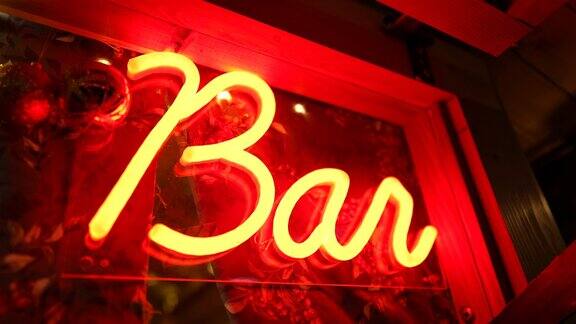 酒吧的荧光灯标志在夜间流动的大门红条广告业务在黑暗中发光