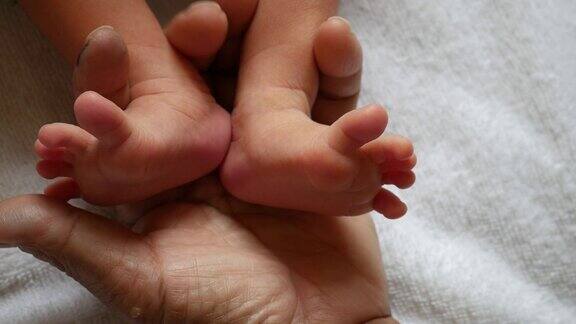 婴儿的脚在妈妈的手里新生儿的脚上是女性