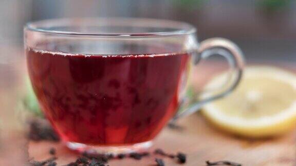 特写杯盛满新鲜的热红茶暖饮料在厨房服务桌与柠檬