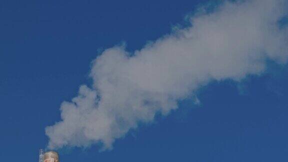 在蓝天的映衬下烟从烟囱里冒出来生态学与温室效应概念瑞典