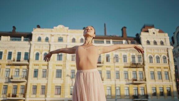 优雅的芭蕾舞者举起双手在城市中舞动