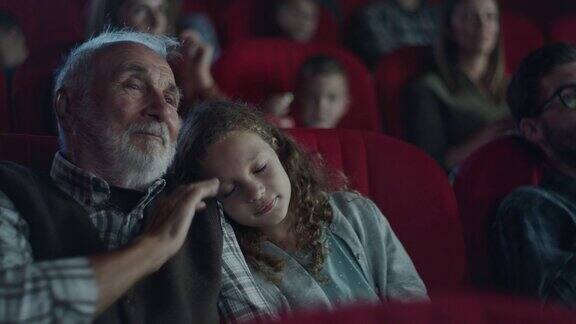 在电影院小女孩睡在爷爷的肩膀上