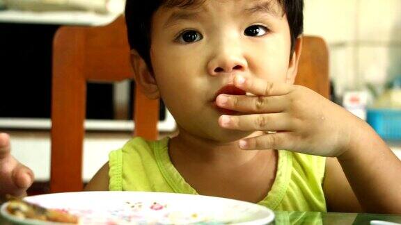泰国小孩在桌上吃食物