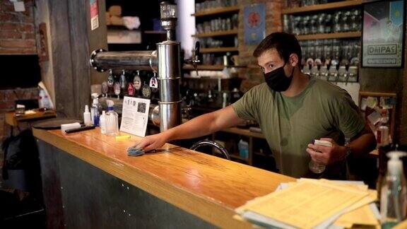 服务员在开啤酒厂前使用消毒产品清洁吧台