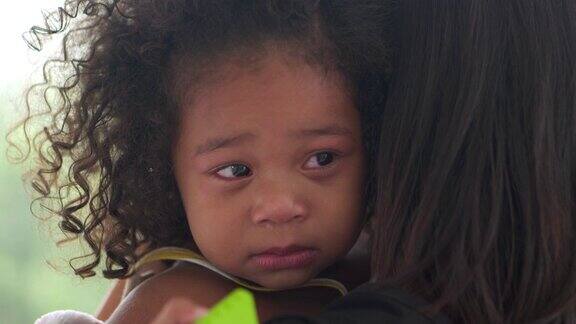 非裔美国儿童哭泣她的母亲在拥抱她