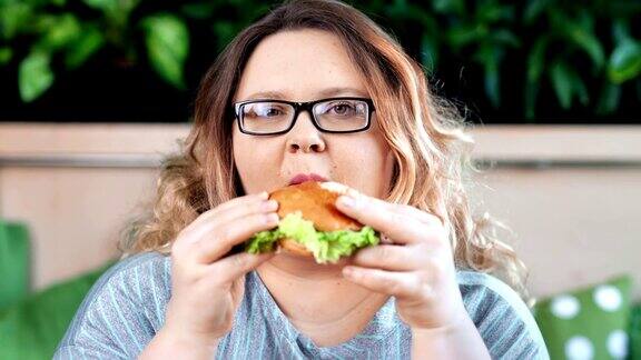 特写镜头的胖女人享受吃新鲜可口的汉堡看着镜头