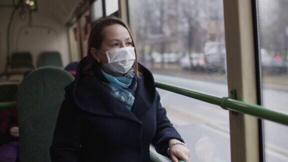 在公共汽车上戴着医用防护口罩的妇女