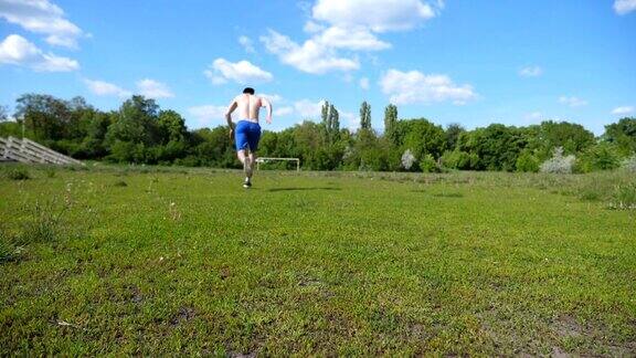 一名面目全非的运动员在比赛前蹲在起跑线上在草地上开始奔跑年轻人在短跑起跑点慢动作