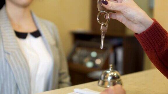 在旅馆的接待处接待员把房间钥匙给客人