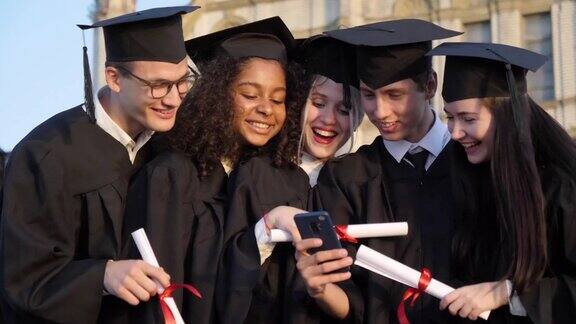 毕业那天一群开心的学生在手机上笑着