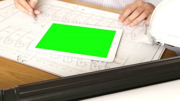 建筑师在绿色屏风的桌子上工作