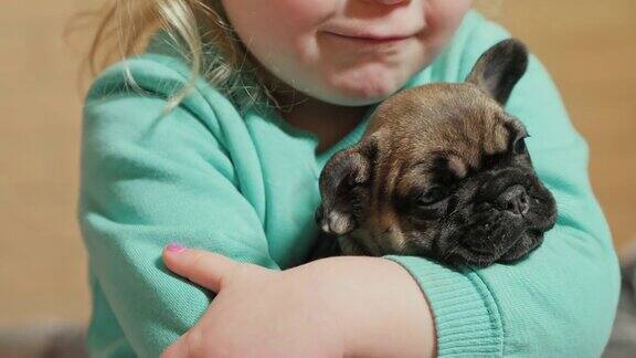一个小女孩抱着一只小狗轻轻地亲吻它