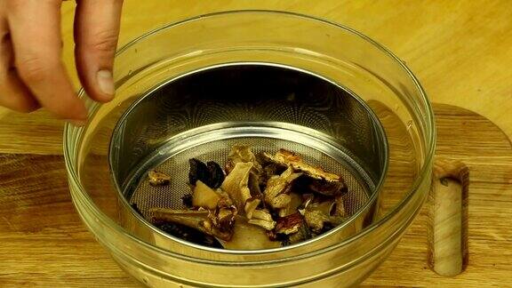浸泡过的干蘑菇放在滤锅里