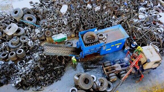 废物回收工厂汽车起重机将旧轮胎装入碎纸机进行回收鸟瞰图