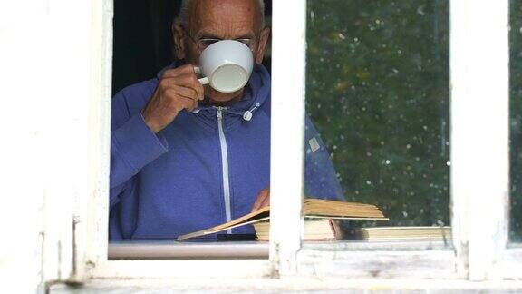 老人在窗台上看书喝茶