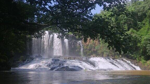 一个令人印象深刻的瀑布的部分视图在背景被一棵热带树包围着