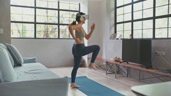 年轻女子在家中客厅佩戴VR头戴式跑步模拟器运动手机app