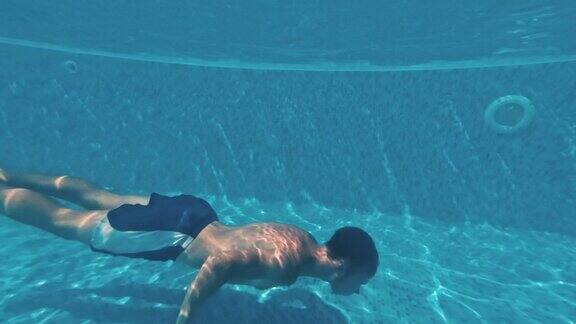 一个年轻人在游泳池的水下游泳