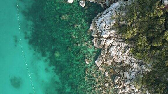 无人机俯瞰海洋和海滩上的岩石KhoTao岛泰国飞行在清澈的蓝色海水上方令人惊讶的低航拍海面股票视频